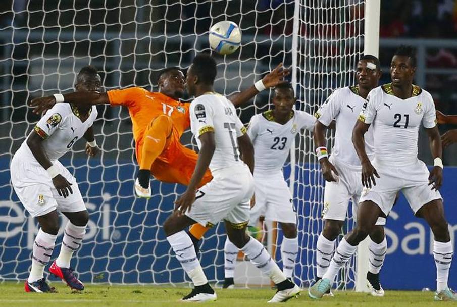 Serge Aurier tenta l&#39;acrobazia circondato da giocatori ghanesi. Action Images